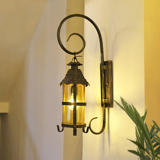 Rustic Lantern Wall Mounted Light Fixture with Scroll Arm in Antique Bronze