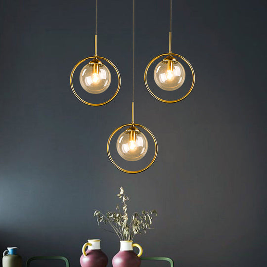 Postmodern Glass Pendant Light with Brass Ring for Bedroom - Single-Bulb Globe Down Lighting in Clear, Amber, and Smoke Grey